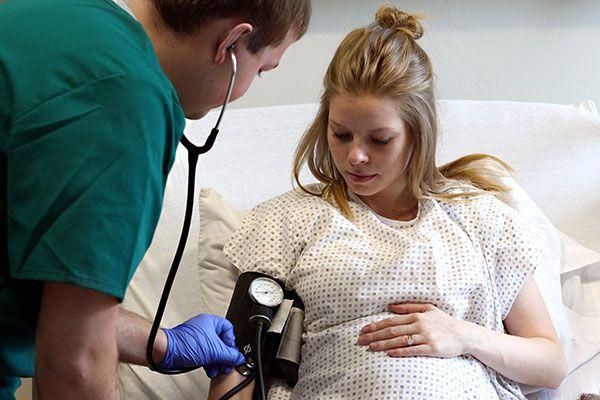 Pregnant lady having her blood pressure taken by medical staff